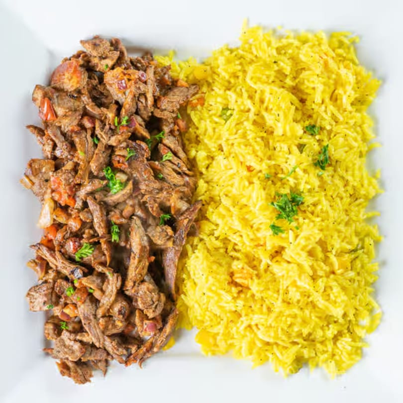 Jasmine Grill's Mediterranean dish with seasoned meat and yellow rice, garnished with parsley.