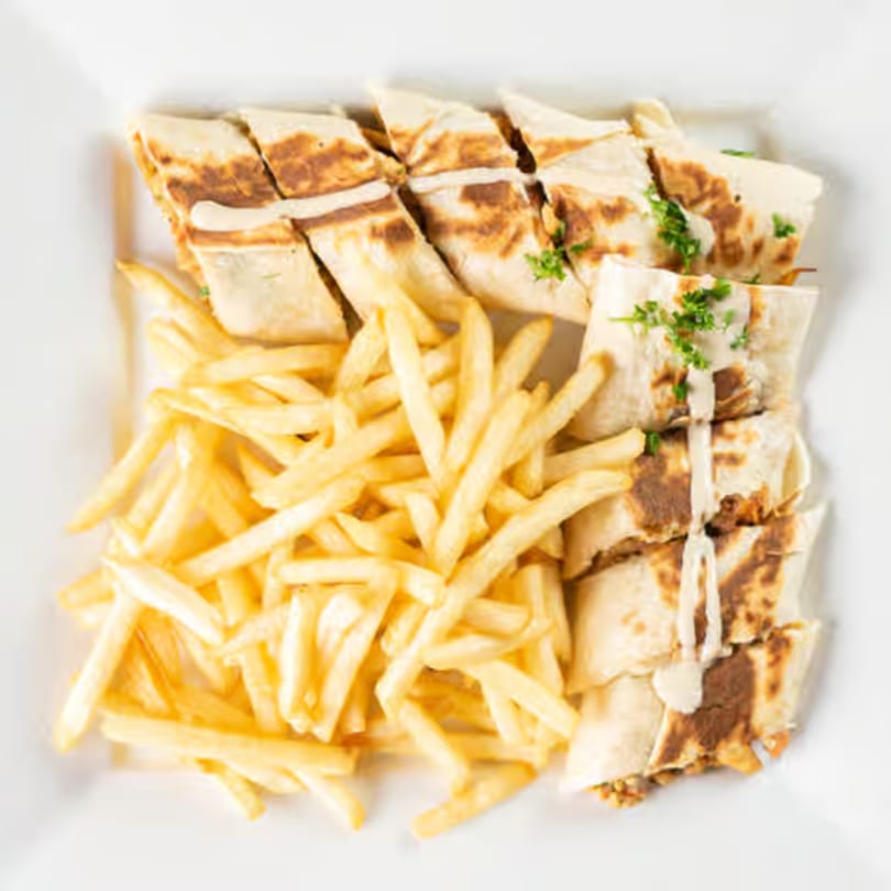 Jasmine Grill's Mediterranean shawarma wraps, drizzled with sauce and garnished with parsley, served with fries.