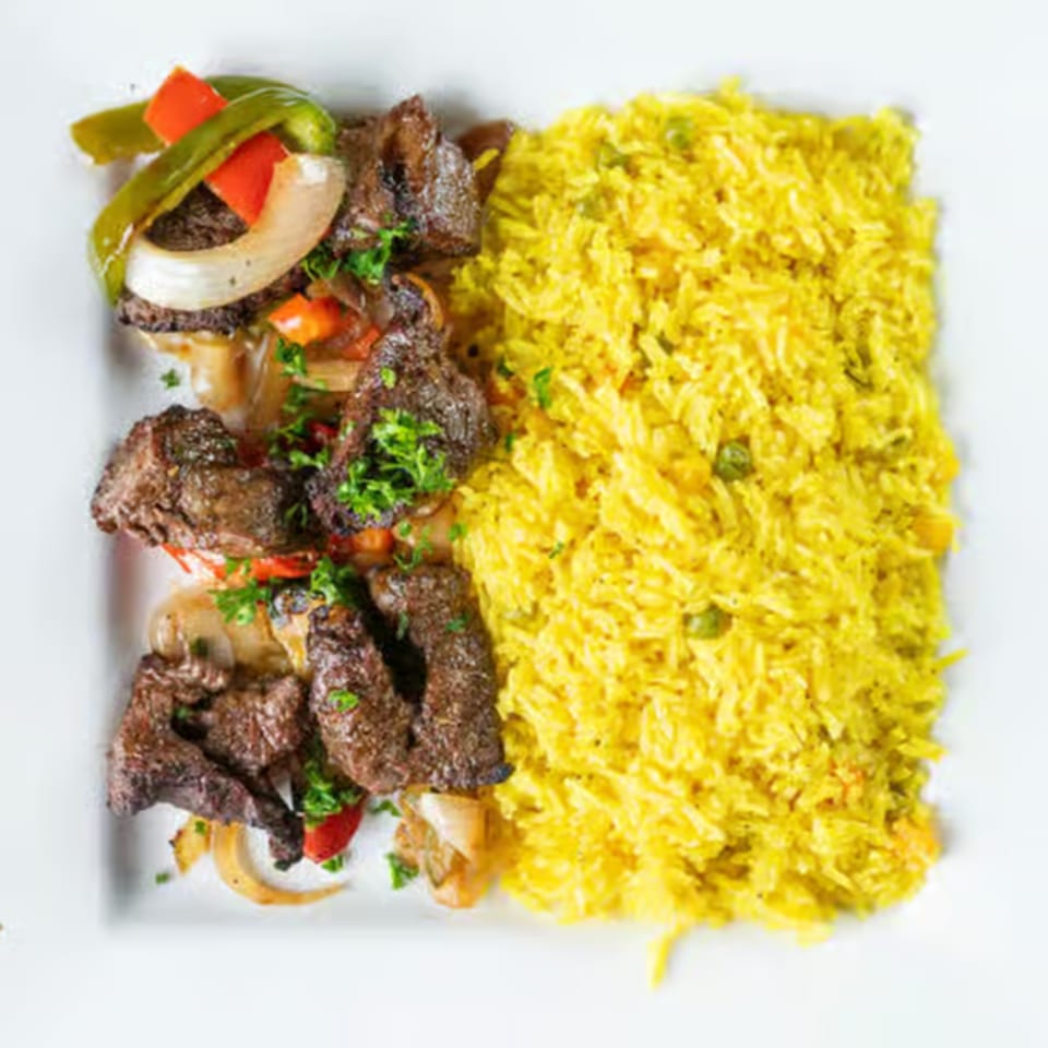 Jasmine Grill's Mediterranean dish with seasoned meat, sautéed vegetables, and yellow rice.